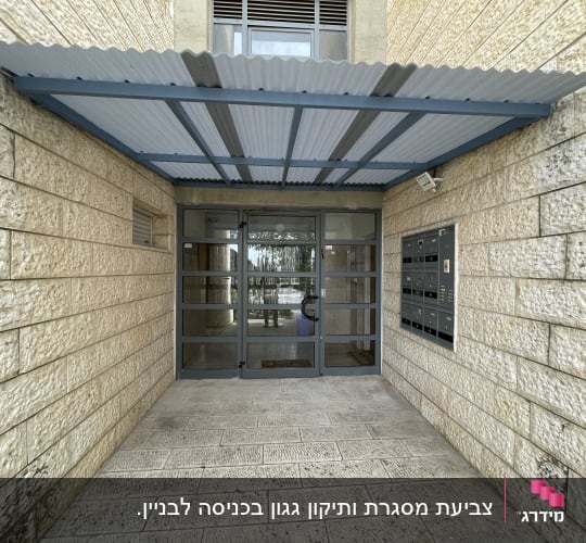 סככה מעל כניסה לבניין עם דלתות זכוכית